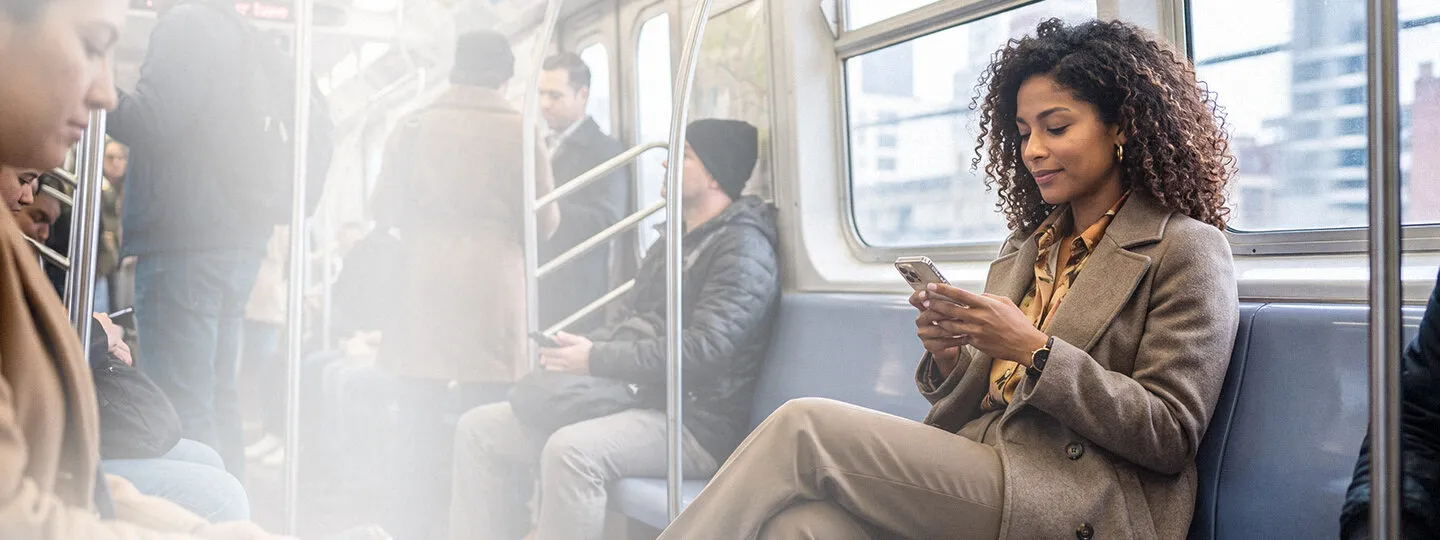 Business professional using a smartphone to explore digital content while commuting.