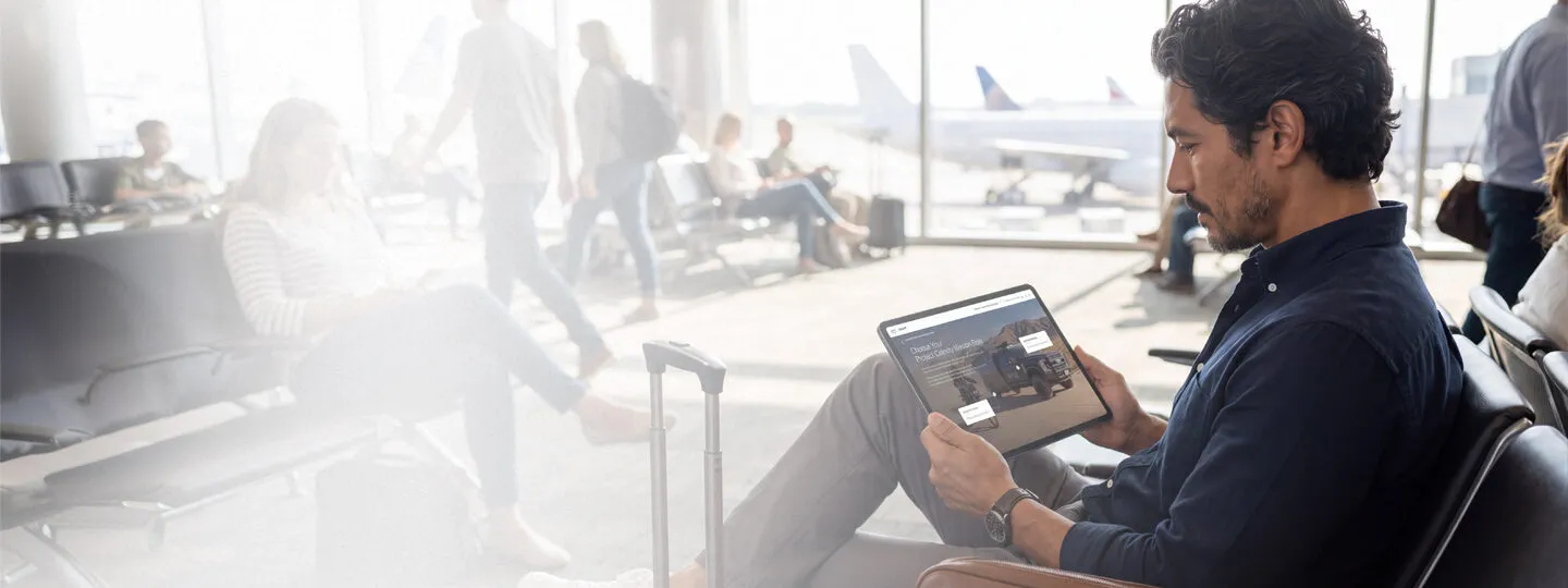 Business buyer exploring an interactive product experience on a tablet while traveling.