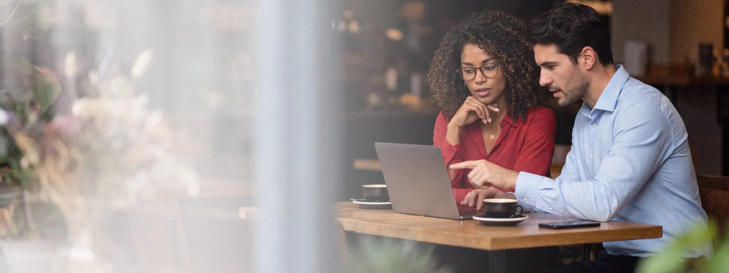 Two business professionals reviewing a digital product experience together on a laptop.